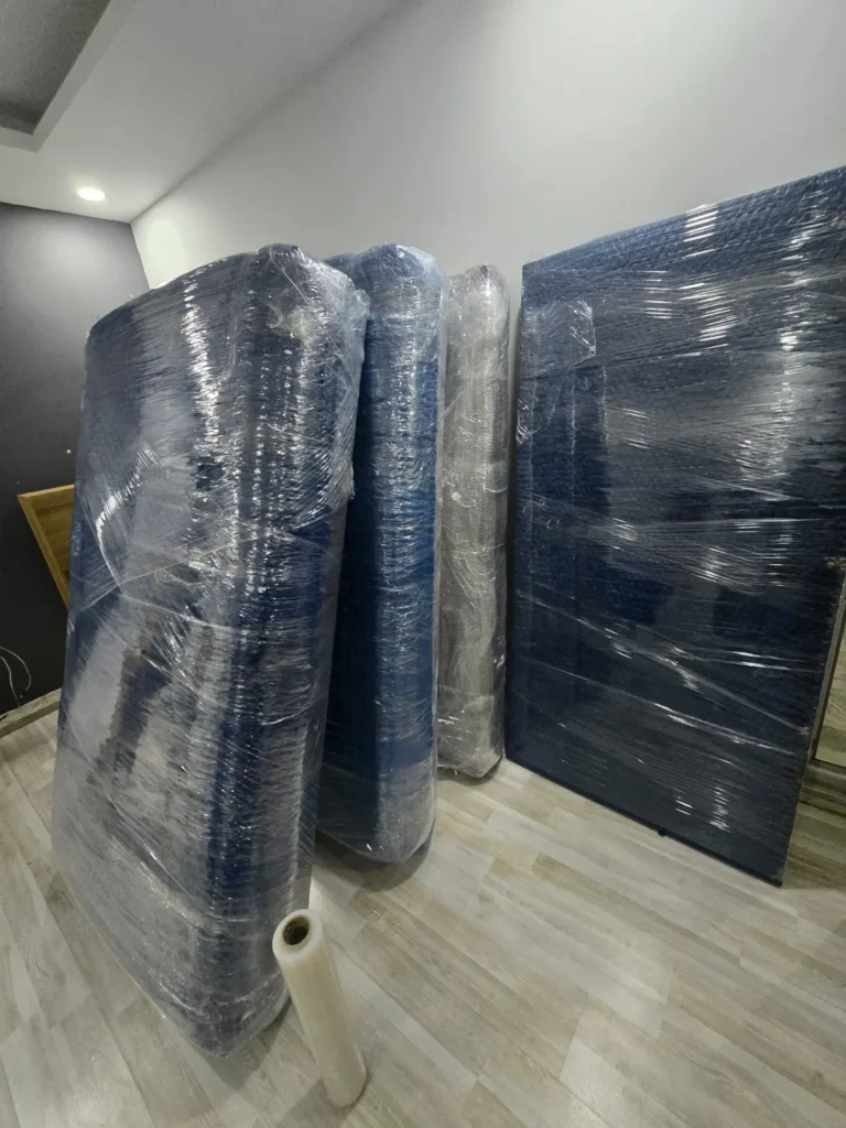 Taşıma öncesi streç film ve battaniye ile paketlenmiş yatak ve bazalar